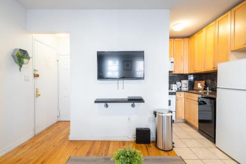 a kitchen with white walls and wooden cabinets at 350-GA Spacious Studio Gramercy Sleeps 3 in New York