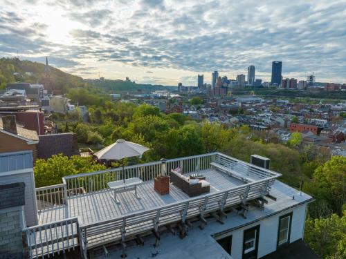 a house with a deck with a view of a city at Stunning Apt w Rooftop & Game Room - Sleeps 10 in Pittsburgh