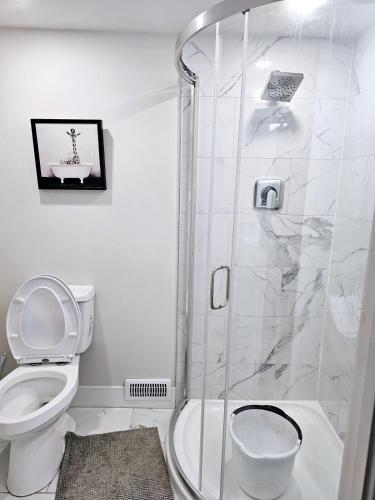 a white bathroom with a shower with a toilet at 1 Bedroom Apartment with Living Room and Full Washroom to yourself alone and a private car park in London
