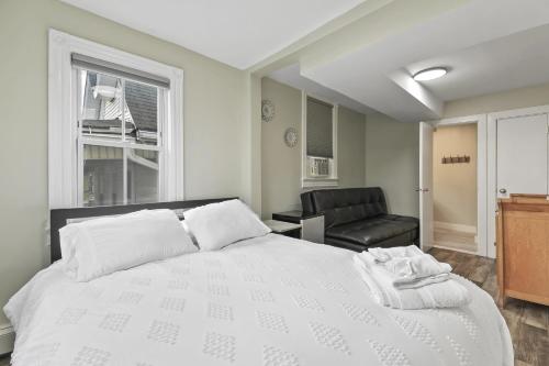 a bedroom with a large white bed and a chair at The Inn At Ocean Grove in Ocean Grove