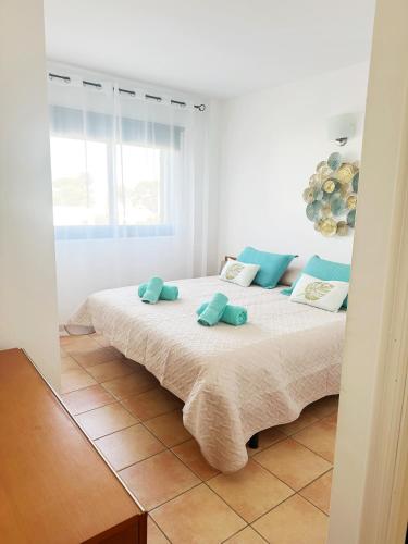 a bedroom with a large bed with blue pillows at Can Blau Formentera Apartamento in Es Pujols