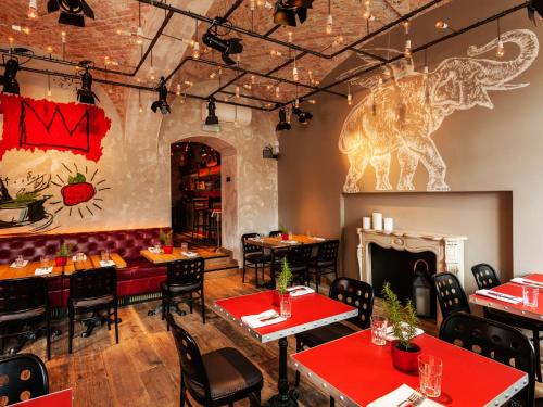 a restaurant with tables and chairs and a fireplace at BALTAZÁR Boutique Hotel in Budapest