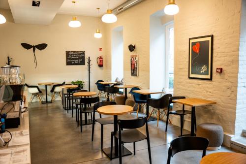 a restaurant with tables and chairs in a room at Tiszavirág Szeged in Szeged