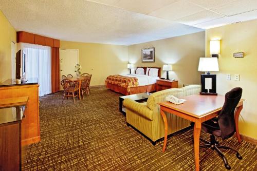 a hotel room with a bed and a couch and a desk at Holiday Inn Missoula Downtown by IHG in Missoula