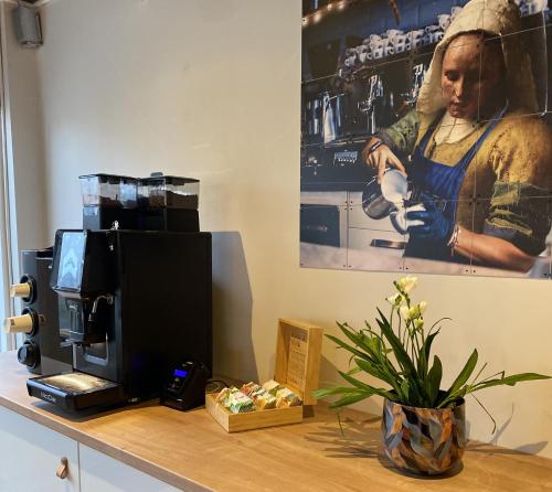a desk with a television and a coffee maker on it at Hotel Emilia in Kaatsheuvel