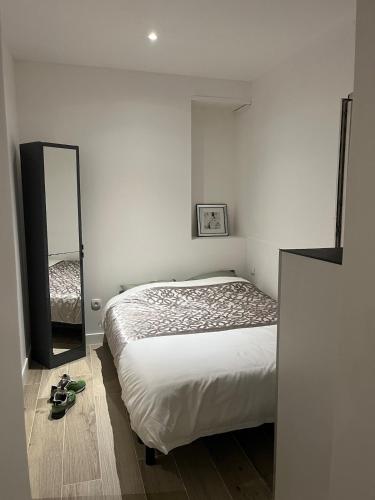 - une chambre avec un lit et un miroir à l'étage dans l'établissement Bel appartement F2 rénové plein centre ville, à Pont-à-Mousson
