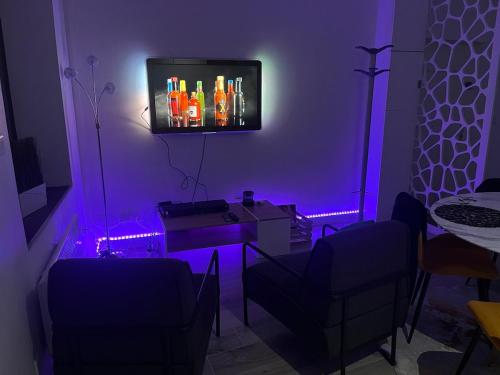 a living room with purple lighting and a tv at Bel appartement F2 rénové plein centre ville in Pont-à-Mousson