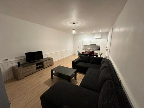 un salon avec un canapé et une télévision dans l'établissement Appartement de 60 m2 au centre ville de morez, à Morez