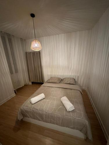 une chambre avec un lit avec deux serviettes dessus dans l'établissement Appartement de 60 m2 au centre ville de morez, à Morez