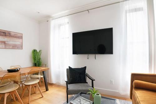 a living room with a table and a television on a wall at 403-3C Newly renovated 3br in prime UES in New York