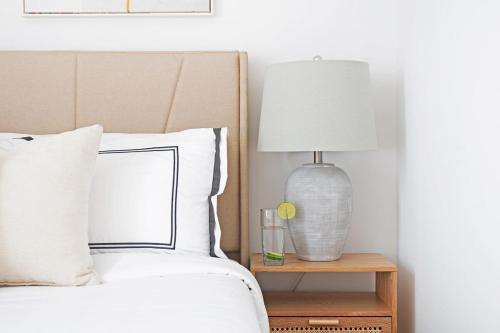a bed with a lamp on a night stand next to it at 403-3C Newly renovated 3br in prime UES in New York