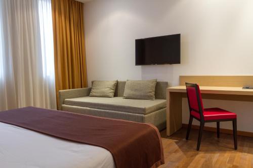 a hotel room with a bed and a desk and a chair at Airporthotel Verona Congress & Relax in Dossobuono