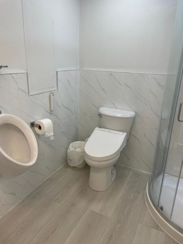a bathroom with a toilet and a urinal and a sink at Rose Garden Vancouver in Richmond