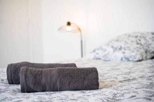 a bed with two pillows on top of it at L'effet mer-T2- Hyper centre in Quimper