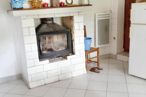 - une cheminée dans la cuisine dotée de carrelage blanc dans l'établissement Chalet chaleureux à Beaufort avec vue sur la montagne, à Beaufort