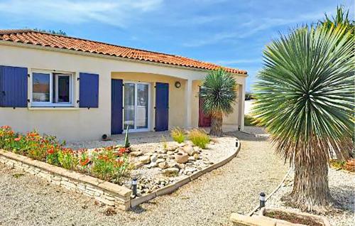 a house with a palm tree in front of it at Awesome Home In Sainte-Gemme-La-Plaine in Sainte-Gemme-la-Plaine