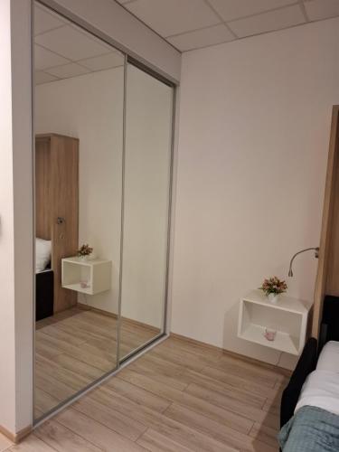 a glass partition in a room with a bed at Zlatarooms in Warsaw