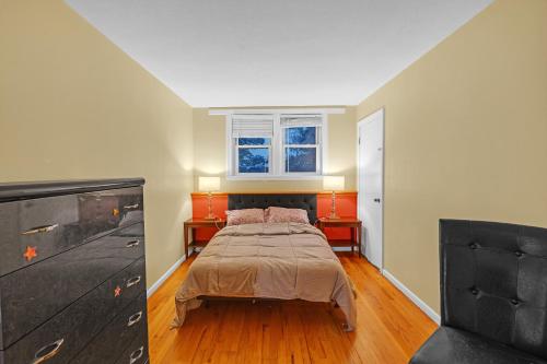 a bedroom with a bed and a dresser and a window at Charming Belmont Condo Near Boston condo in Belmont