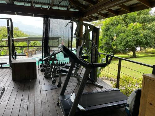 a gym with several tread machines on a deck at Searenity Octopus Cottage in Port Antonio