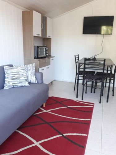 a living room with a couch and a table at Cabaña para 2 personas en Valdivia in Valdivia