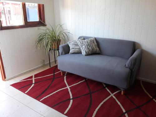 a blue couch in a room with a red rug at Cabaña para 2 personas en Valdivia in Valdivia