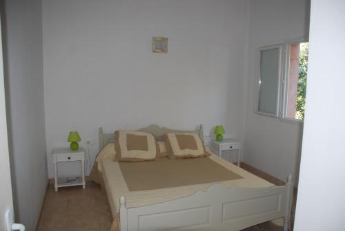1 dormitorio con 1 cama con 2 mesas y una ventana en Residence Ribellinu, en Pianottoli-Caldarello