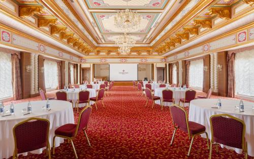 a banquet hall with white tables and chairs and a screen at Shamakhi Palace Sharadil in Şǝrǝdil