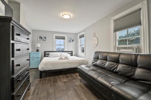una camera con letto e divano in pelle di The Inn At Ocean Grove a Ocean Grove
