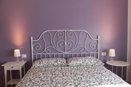 um quarto com uma cama com uma parede roxa em Sogni d'Assisi em Assis