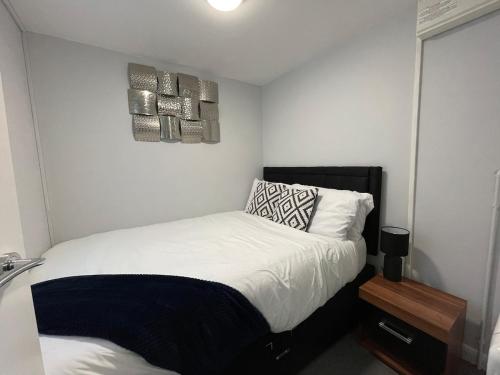 Un dormitorio pequeño con una cama y un espejo. en Parkside Apartments Boston, en Boston