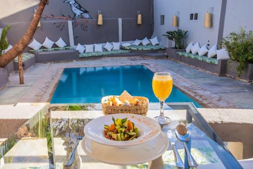 a table with a bowl of food and a drink next to a pool at LE Piccolo Bike Camp in El Karia