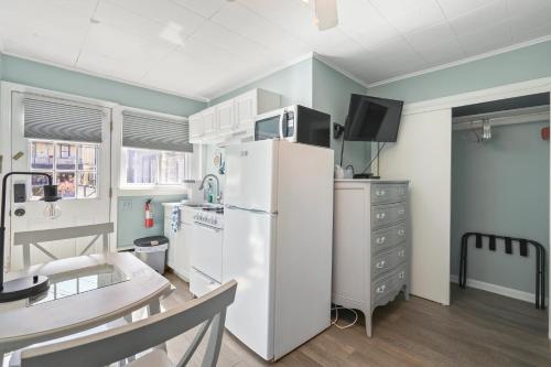 a kitchen with a white refrigerator and a table at The Inn At Ocean Grove in Ocean Grove