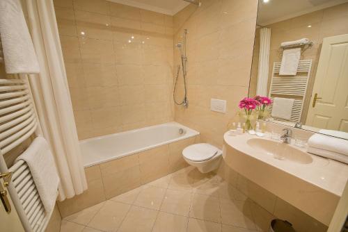 a bathroom with a sink and a toilet and a bath tub at Angelis in Prague
