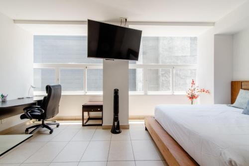 a bedroom with a bed with a flat screen tv on a pole at J604 - 1BR - 1BTh in Mexico City