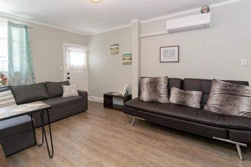 a living room with a black couch and a table at The Inn At Ocean Grove in Ocean Grove