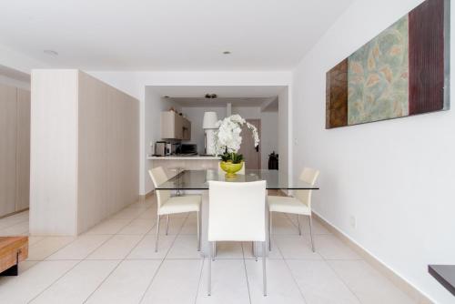 a dining room with a glass table and white chairs at J604 - 1BR - 1BTh in Mexico City