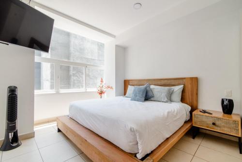 a bedroom with a bed and a flat screen tv at J604 - 1BR - 1BTh in Mexico City