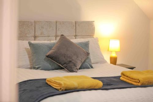 a bedroom with a bed with two towels on it at Foxglove House & Hot Tub Stansted Airport in London Stansted Airport