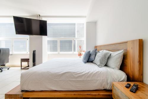 a bedroom with a bed with a tv on the wall at J604 - 1BR - 1BTh in Mexico City