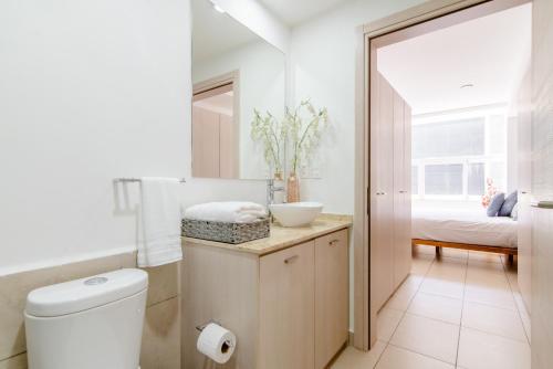 a bathroom with a toilet and a sink and a bed at J604 - 1BR - 1BTh in Mexico City