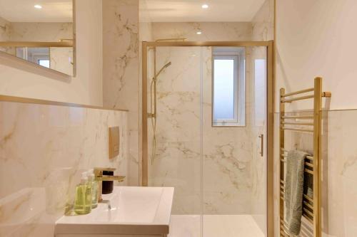 a white bathroom with a shower and a sink at Foxglove House & Hot Tub Stansted Airport in London Stansted Airport