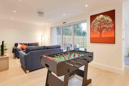 a living room with a table with a foosball at Foxglove House & Hot Tub Stansted Airport in London Stansted Airport