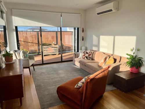 a living room with a couch and a table at Bright, spacious apartment in Torquay in Torquay