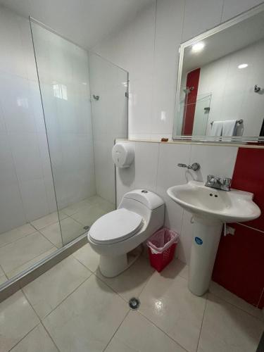a bathroom with a toilet and a sink and a shower at Hotel Suite Continental in Barranquilla