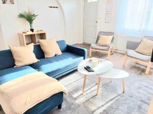 un salon avec un canapé bleu et deux chaises dans l'établissement La Belle Du Thil - Spacieuse Et Proche Aéroport, à Beauvais