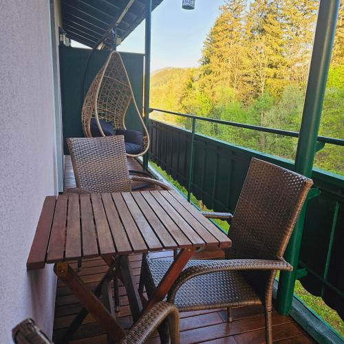 a porch with a wooden table and chairs and a swing at Ferienwohnung Blick ins Grüne in Rossleithen