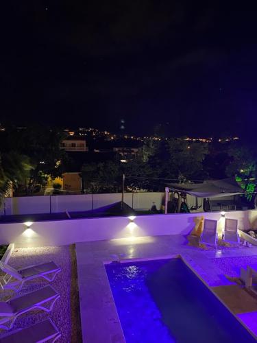 a swimming pool at night with purple lights at 4BlessingsCuracao1 in Willemstad