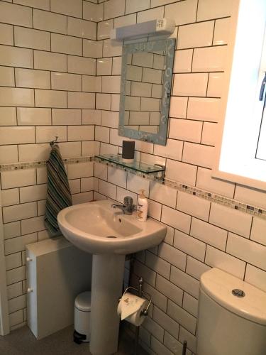 a white bathroom with a sink and a toilet at Lark Rise B&B in Wangford