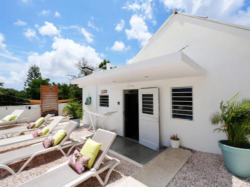 a white house with lounge chairs in front of it at 4BlessingsCuracao1 in Willemstad