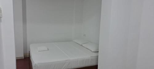 a bed with white sheets and pillows in a room at Villa Paradiso in Wadduwa